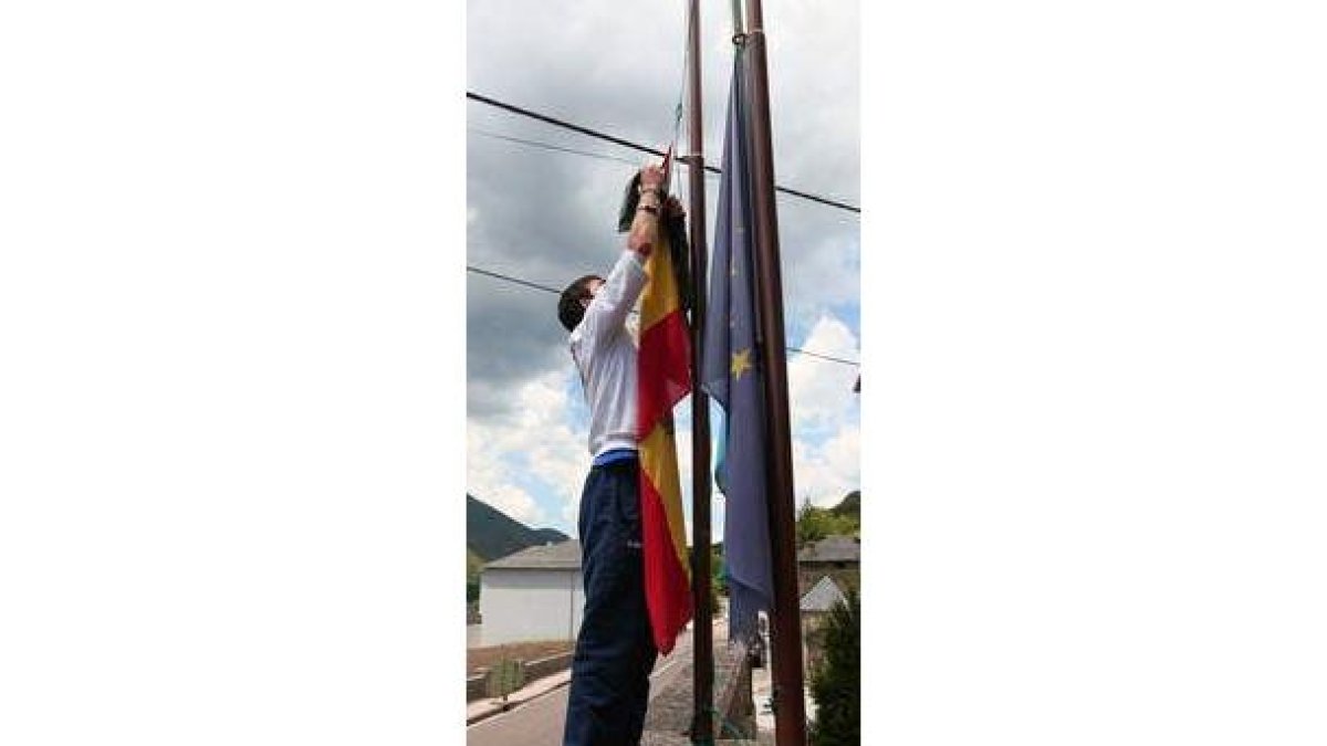 Un joven pone a media asta una bandera en Degaña.
