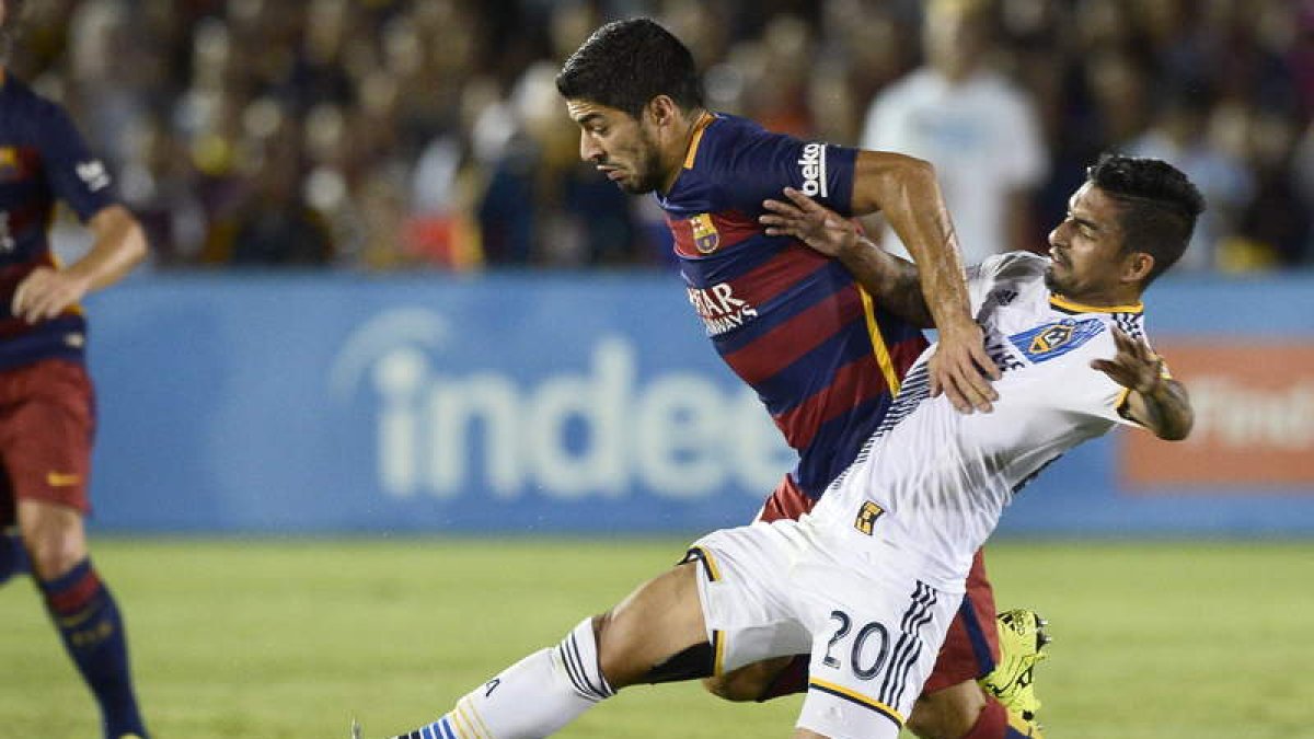 Luis Suárez pelea un balón con De La Garza de los Galaxy.