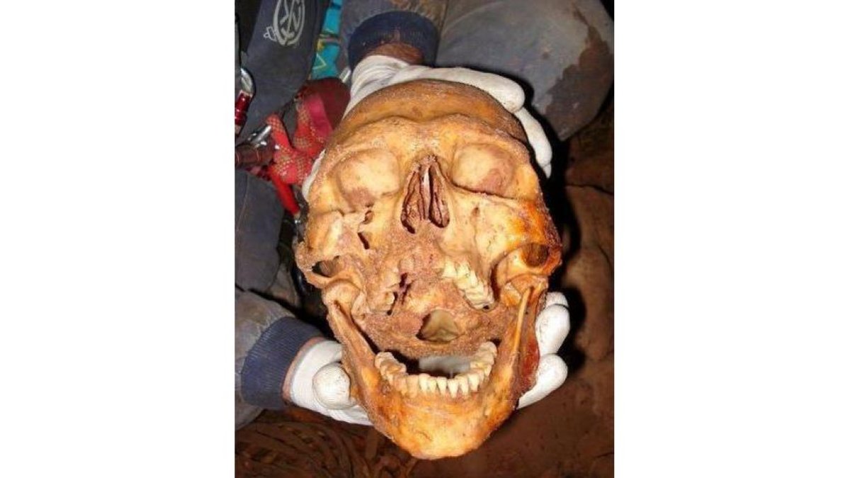 Uno de los descubridores de la cueva de Arintero muestra un cráneo