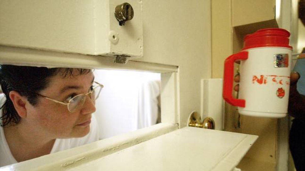 Kelly Gissendaner mira por la rendija de la puerta de su celda, en julio del 2004.