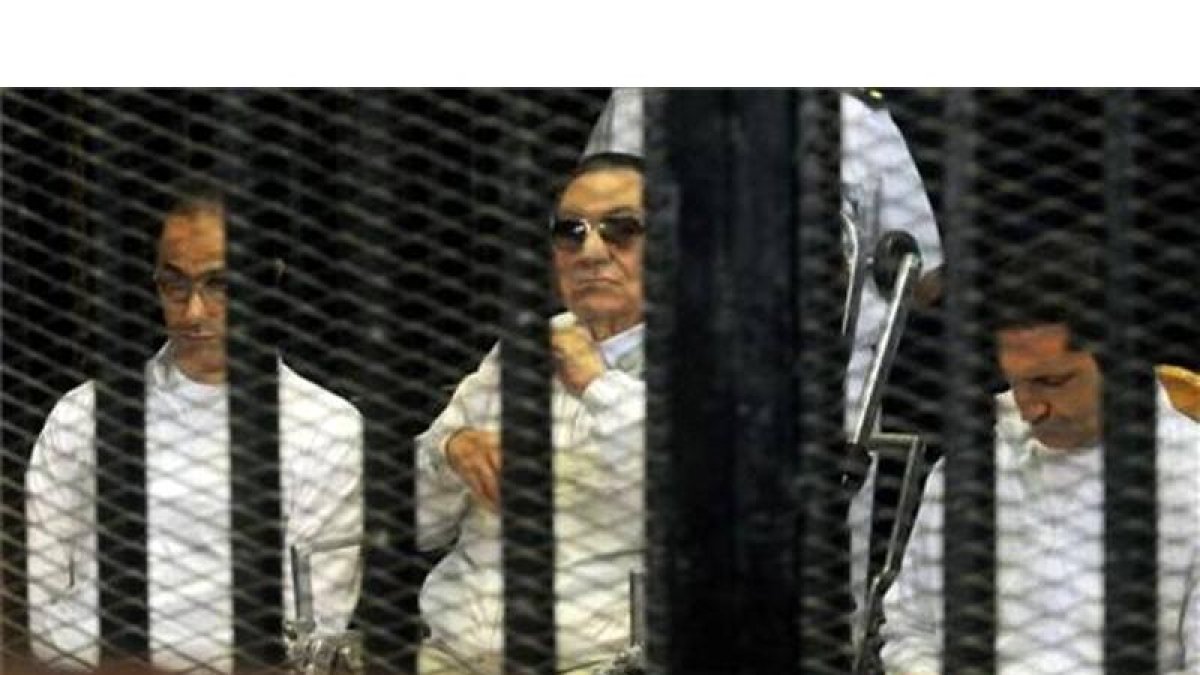 El expresidente egipcio, Hosni Mubark, junto a sus hijos Alaa (derecha) y Gamal (izquierda) a la entrada de la Academia de Policía, en el Cairo, este domingo.