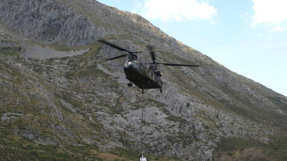 El Chinook del Ejército de Tierra traslada los restos del helicóptero por la ladera de La Polinosa