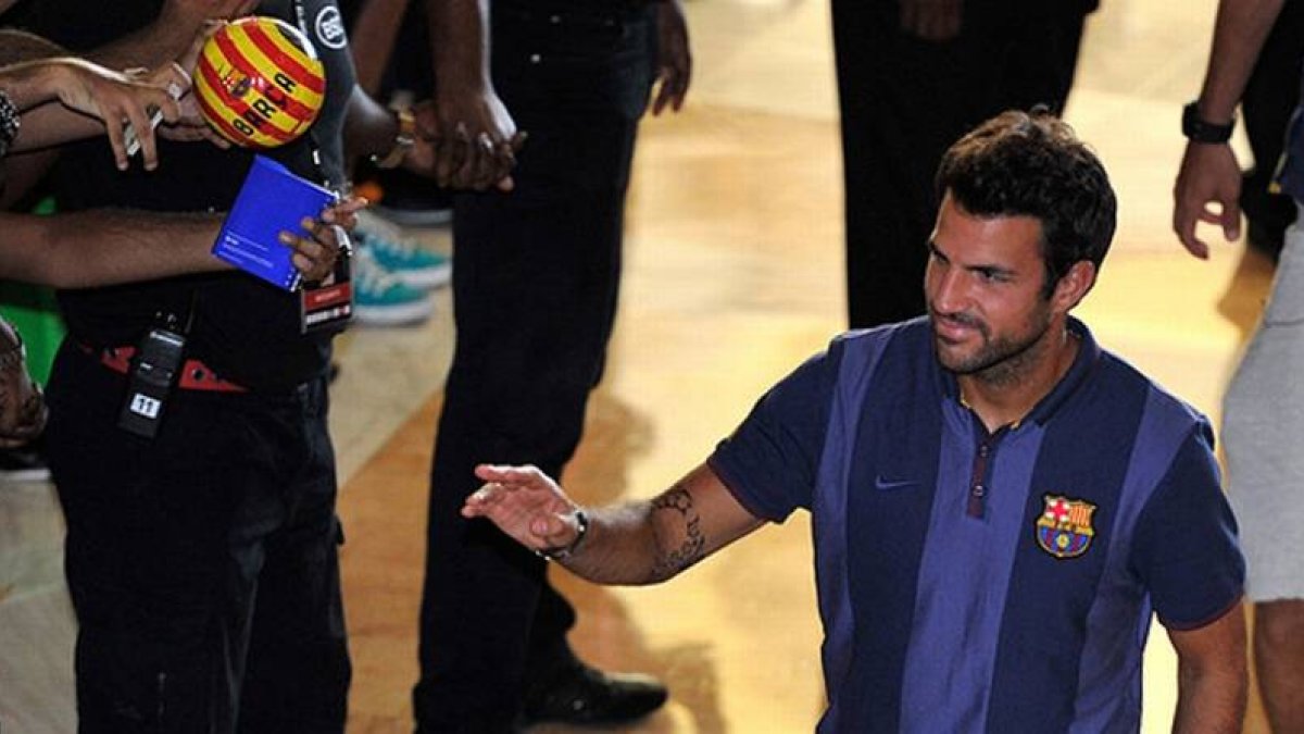 Cesc saluda a un grupo de aficionados malasios en el aeropuerto de Kuala Lumpur.