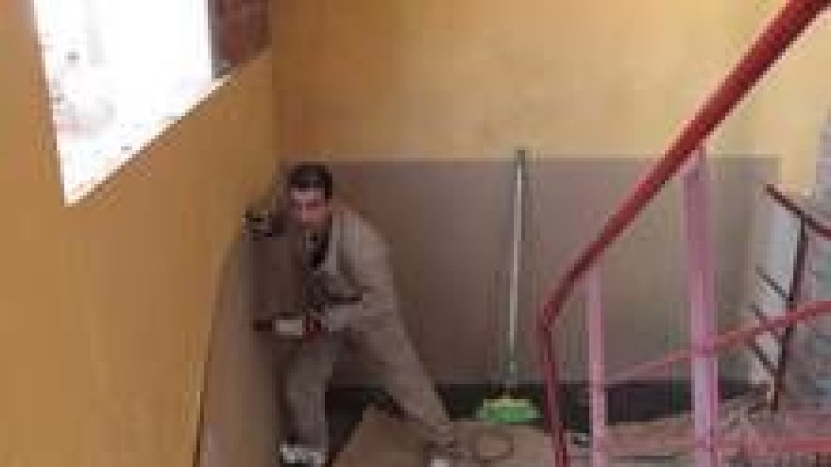 Un carpintero de la brigada municipal de obras panela el interior de la escalera