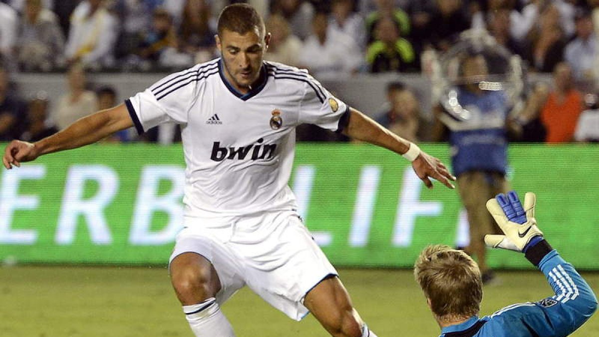 Benzema (i) en acción contra el guardameta Josh Saunders (d) de los Ángeles Galaxy.