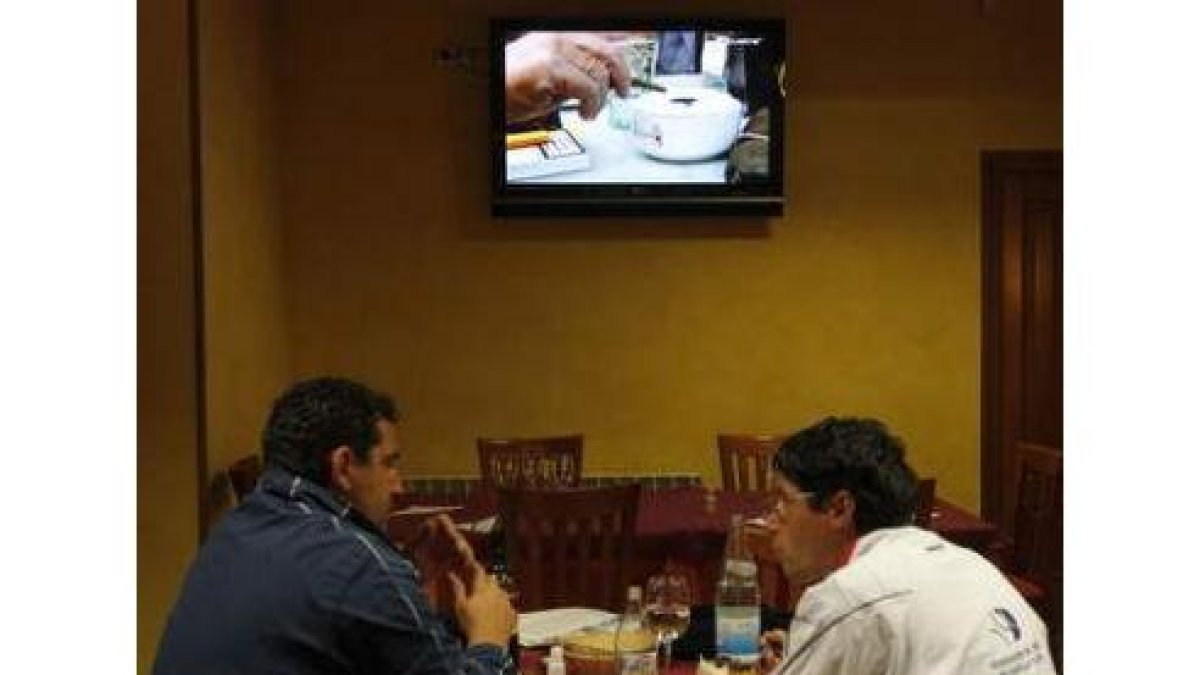 Dos personas comen en una zona habilitada para fumadores de un restaurante leonés.