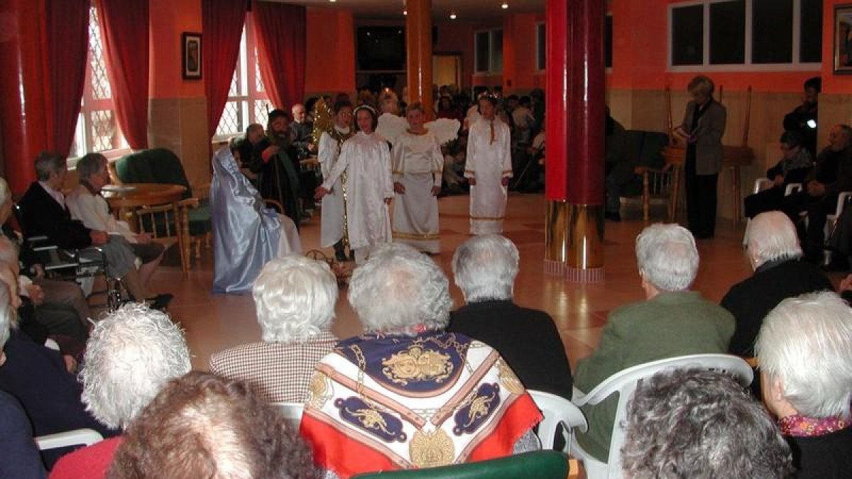 Ancianos en una residencia durante una representación teatral navideña