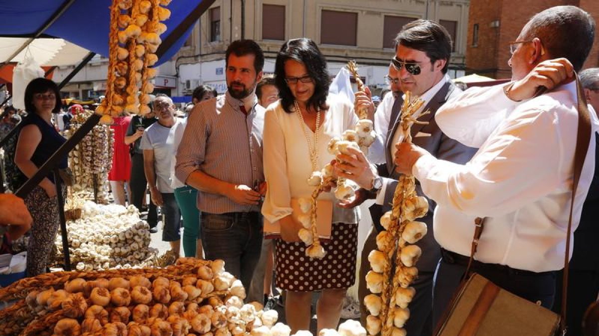 El consejero Suárez-Quiñones con una ristra de ajos durante su visita a la feria de Veguellina.