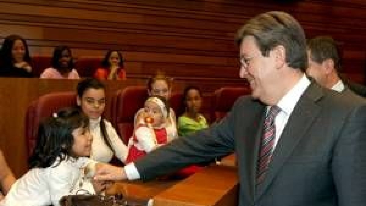 El presidente de las Cortes saluda a uno de los niños participantes en el acto