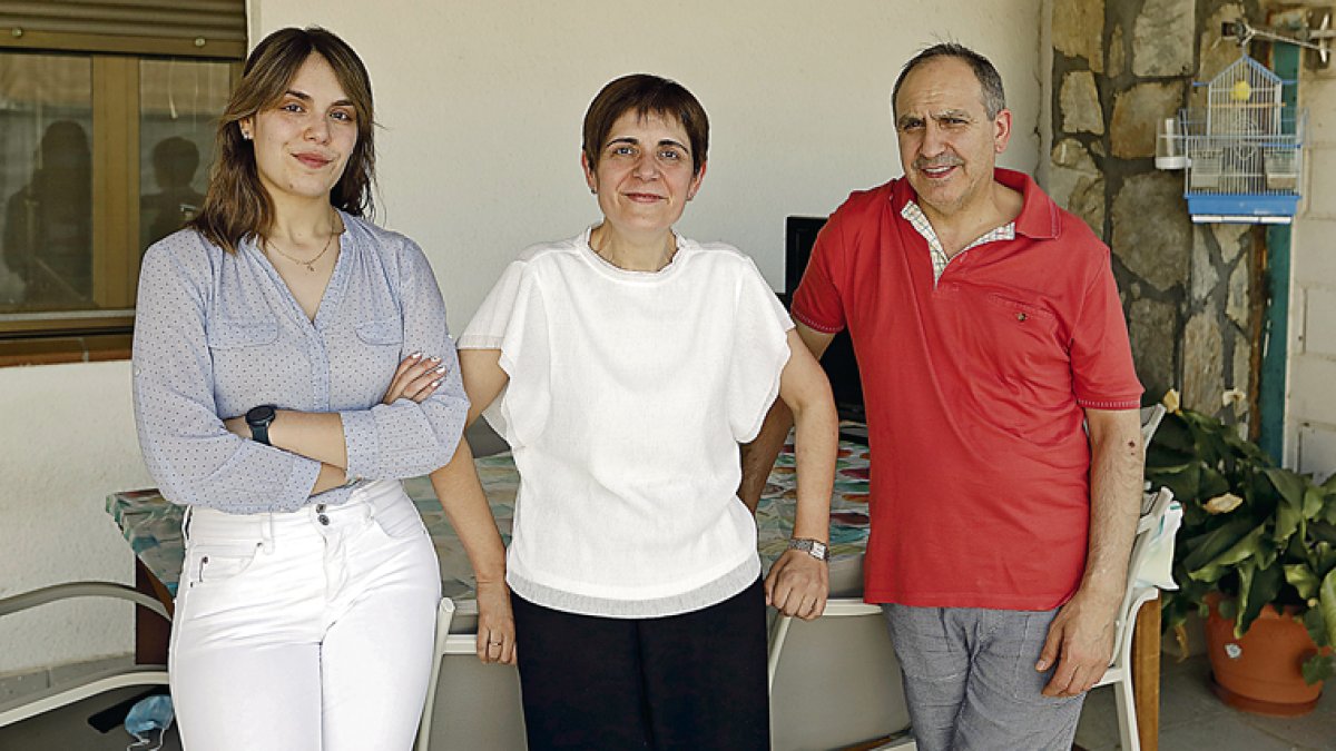Esther Reñoles, paciente de ELA, su marido Agustín y su hija de 25 años en el patio de su casa. MARCIANO PÉREZ