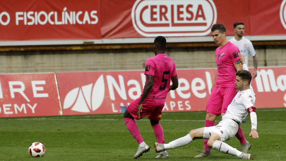 Iván González corta un balón ante la presencia del jugador berciano Yac en un lance del encuentro disputado en el estadio Reino de León. MARCIANO PÉREZ