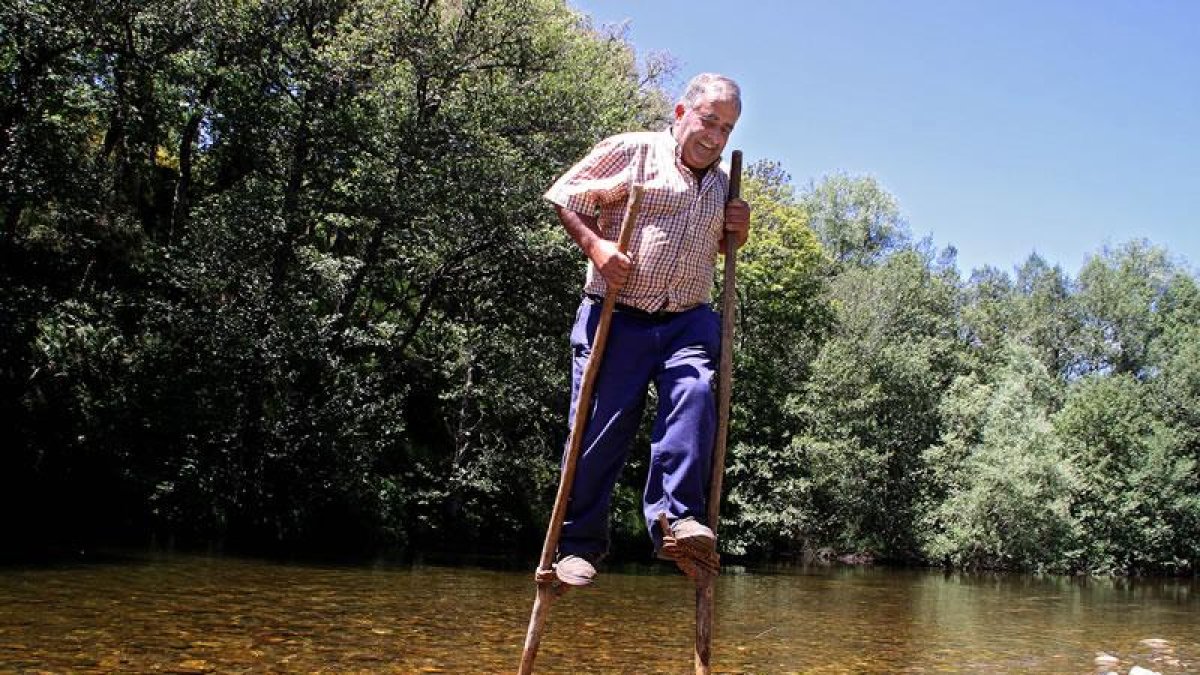 Pepín, presidente de la Junta Vecinal de Trascastro de Luna (León), utiliza unas zancas para atravesar el Omaña.