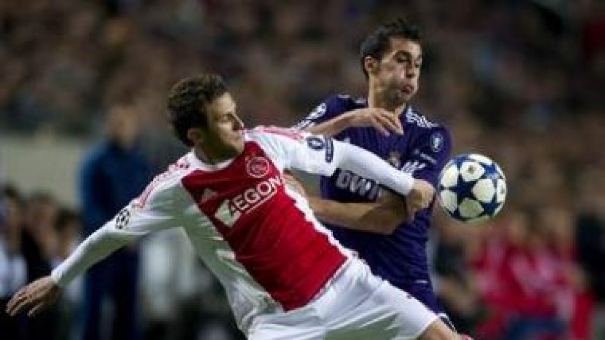 El defensa del Madrid, Álvaro Arbeloa, lucha por el control del balón con Miralem del Ajax.