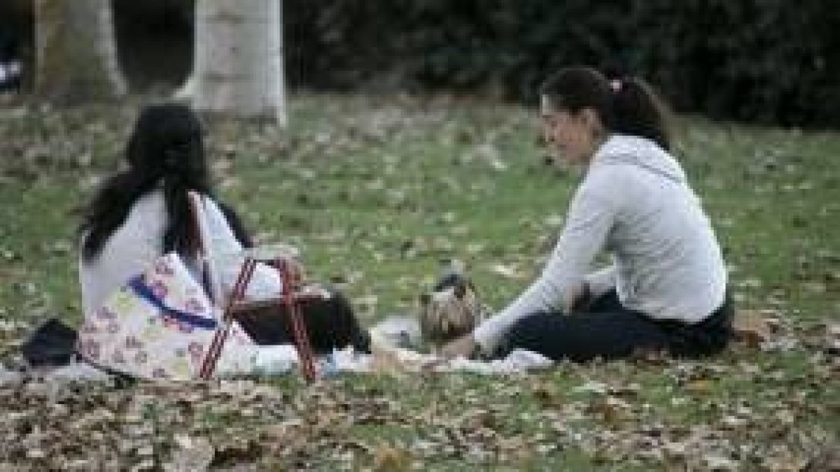 Dos jóvenes disfrutan de la tarde con temperaturas cálidas en un parque de la capital leonesa