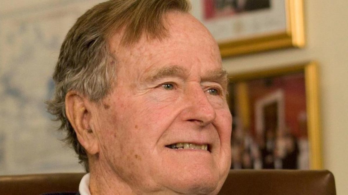 George H.W. Bush sonríe al escuchar al candidato presidencial republicano Mitt Romney, a quien apoyó en la elección del 2012, en un acto en Houston, el 29 de marzo del 2012.