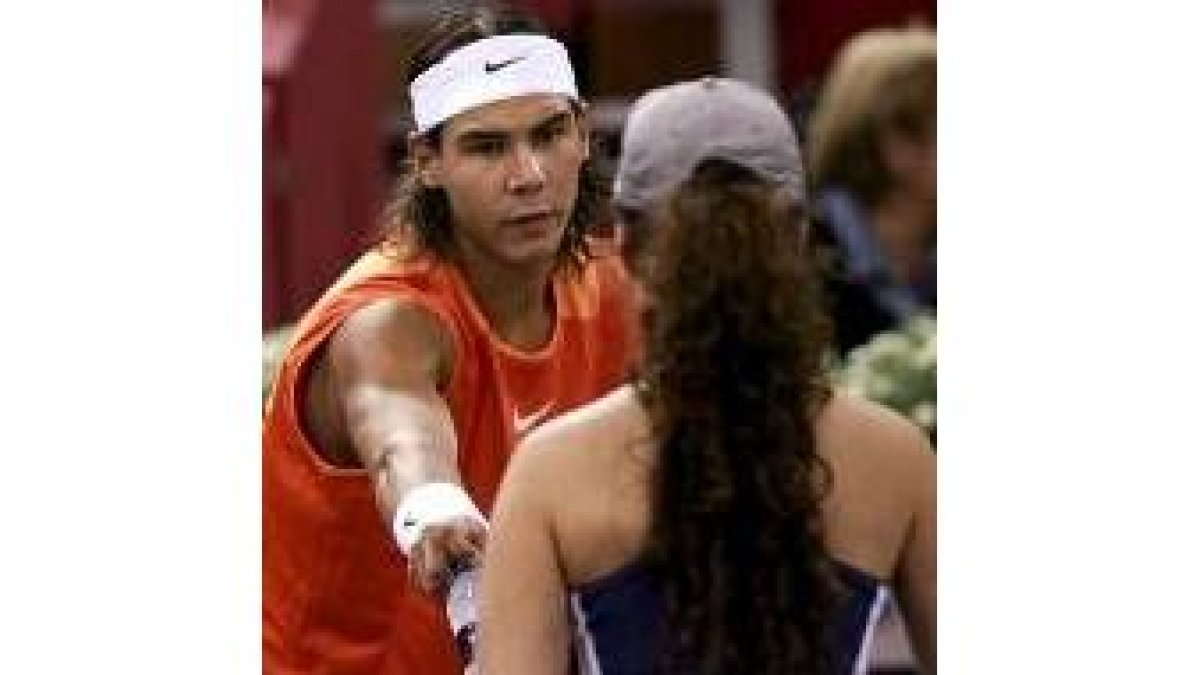 Nadal entrega una botella de una asistente sobre la cancha