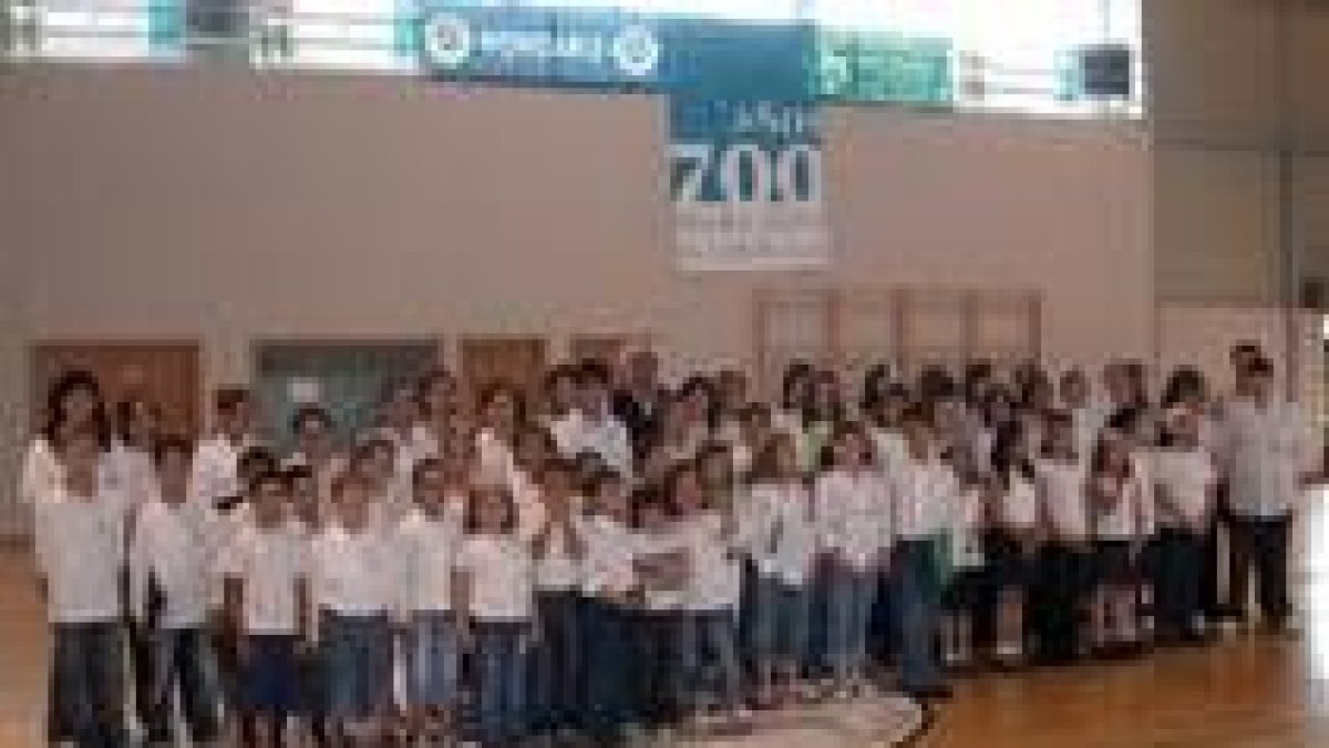 Los coros participantes en el concierto, posan juntos en el pabellón local.
