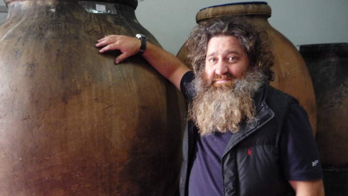 Raúl Pérez Pereira, en la bodega de Valtuille de Abajo, junto a algunas de las grandes tinas de barro que uliliza en la vinificación. B. FERNÁNDEZ
