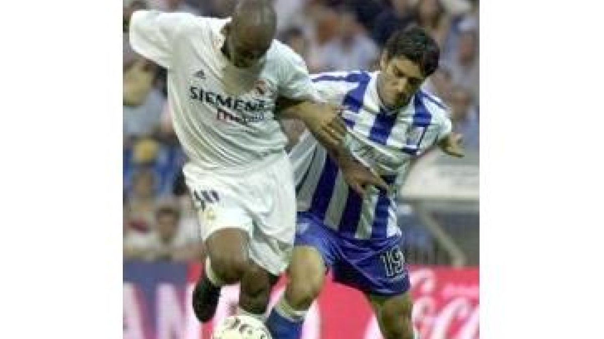 El madridista Flavio, a la izquierda, trata de hacerse con el balón perseguido por Fernando Sanz