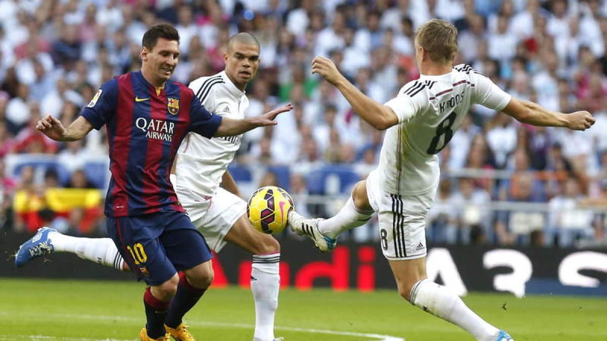 Messi trata de hacerse con el balón ante los jugadores del Madrid Toni Kroos y Pepe durante el partido disputado en el estadio Santiago Bernabéu.