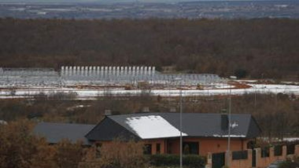 Una vivienda de la urbanización Club de Golf y, al fondo, el huerto solar.