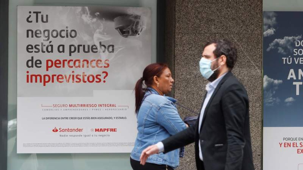 Dos viandantes pasan por delante del Santander. RAMIRO