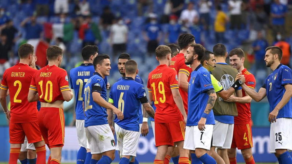 Italianos y galeses celebran su clasificación para octavos de final de la Eurocopa. RICCARDO ANTIMIANI