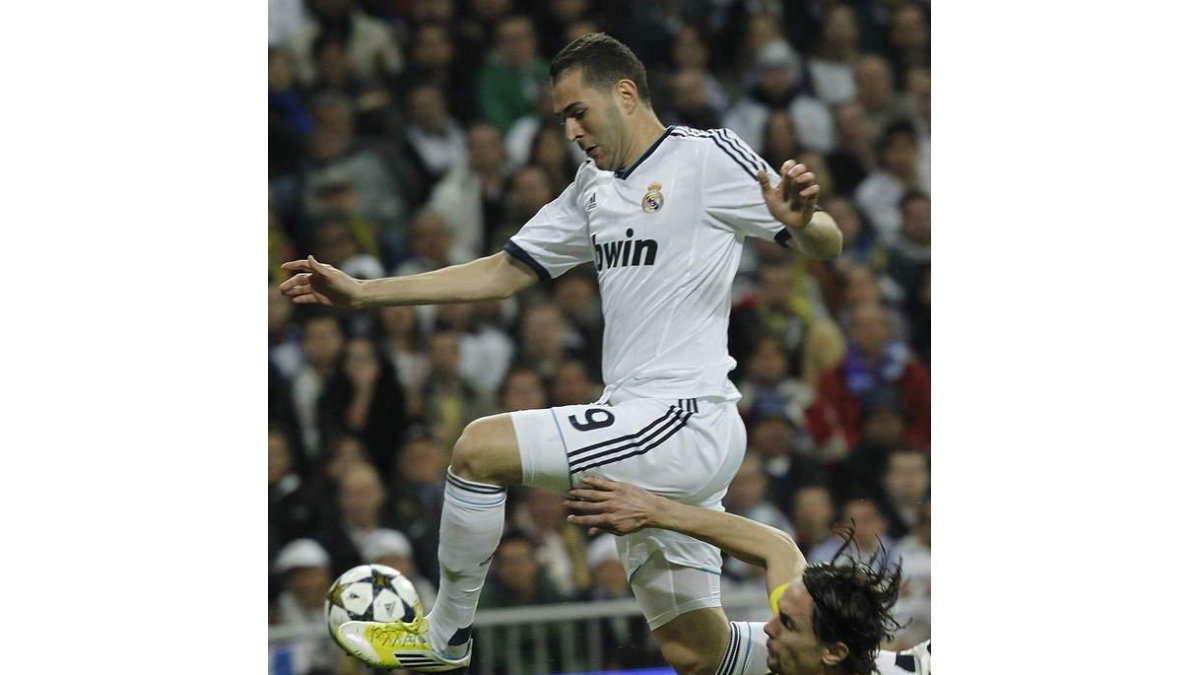 El delantero francés del Real Madrid, Karim Benzema, logra zafarse de un defensor rival.