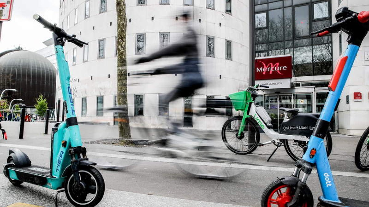 Patinetes de autoservicio en una calle de París junto a un carril bici. TERESA SUÁREZ