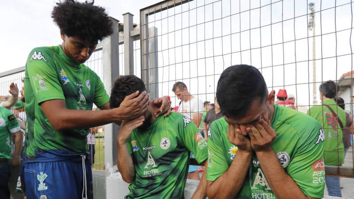 Héctor Taranilla consuela al término del partido a un pequeño seguidor del Atlético Astorga rodeado por Iván Zarandona y Javi Amor. JESÚS F. SALVADORES