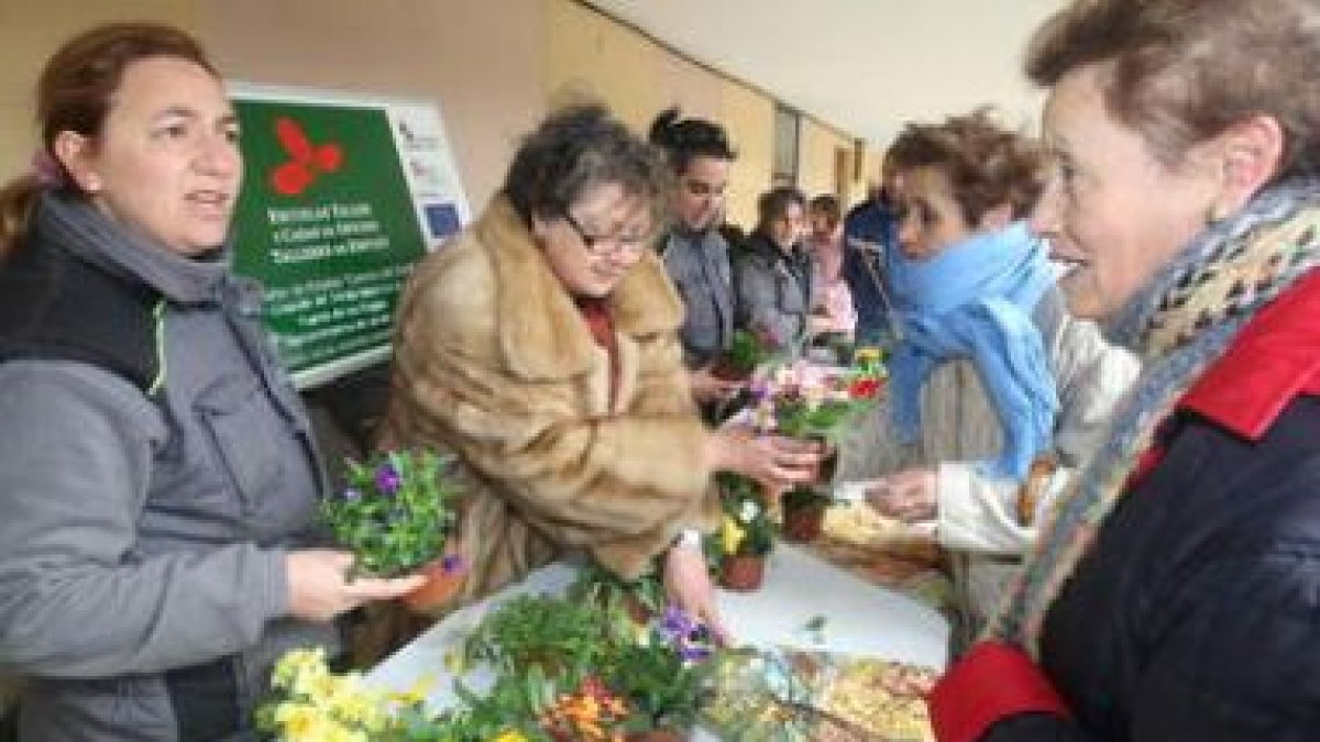 La alcaldesa de Mansilla, Mari Paz Díaz, entrega plantas a una de las vecinas.