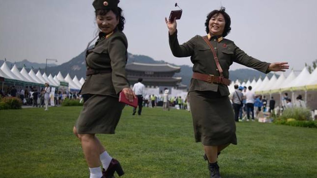 Desertoras de Corea del Norte bailan con uniformes militares de su país de origen en una exposición por la unificación de las dos Coreas, en Seúl, este viernes.
