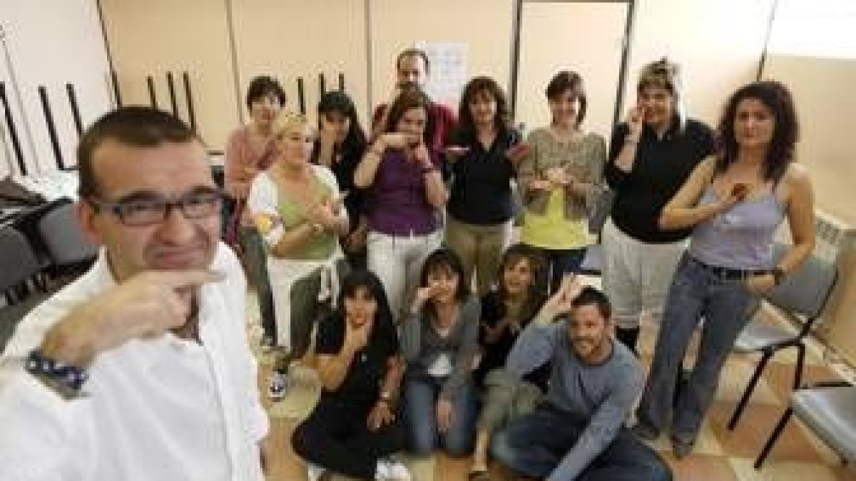 Fernando Javier García posa con las personas en paro dibujando su nombre con un gesto en LSE