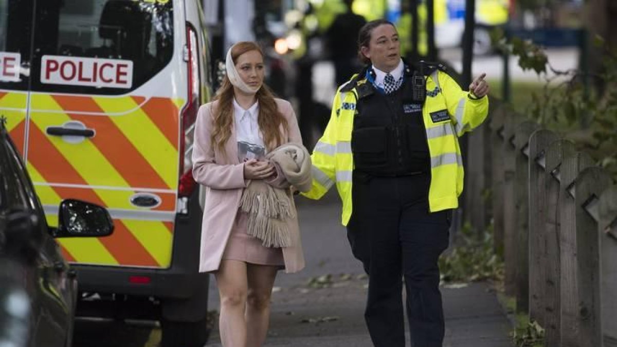 Una agente de policía escolta a una herida en los alrededores de la estación de metro Parsons Green en Londres