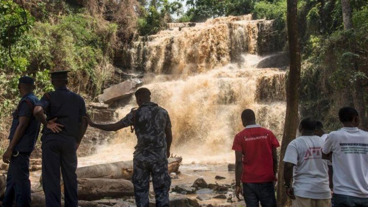Policías y voluntarios frente a la cascada en la que un árbol mató a 18 personas.