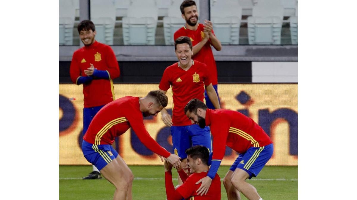 Ramos y Nacho levantan a Morata ante las risas y los aplausos de Piqué, Ander y Silva. JUANJO MARTÍN