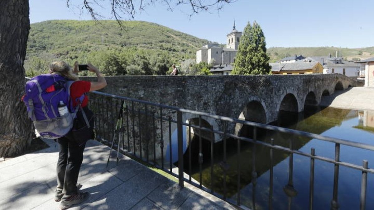 Una pertegrina junto a la playa fluvial de Molinaseca en pleno Camino de Santiago a su paso por León. L.DE LA MATA