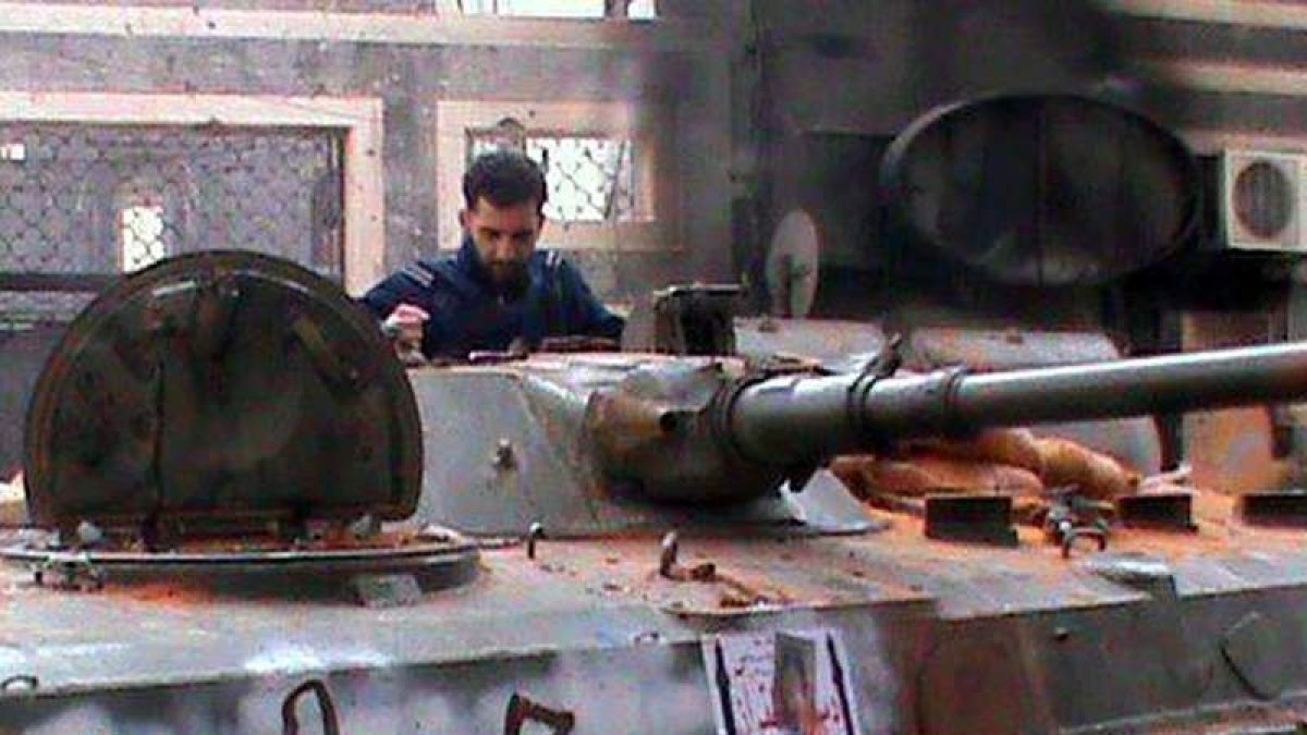Un activista sirio, al lado de un tanque capturado en el bastión opositor de Homs.