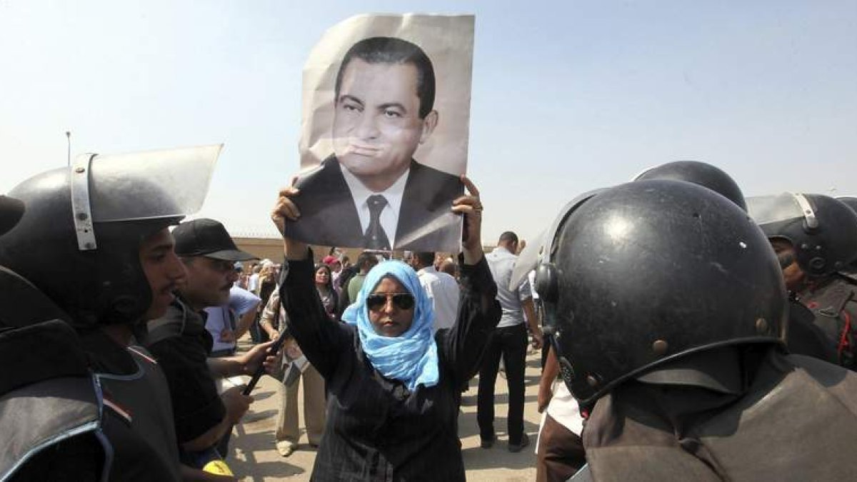 Una mujer sostiene un retrato del expresidente Mubarak, frente a la Academia de la Policía.