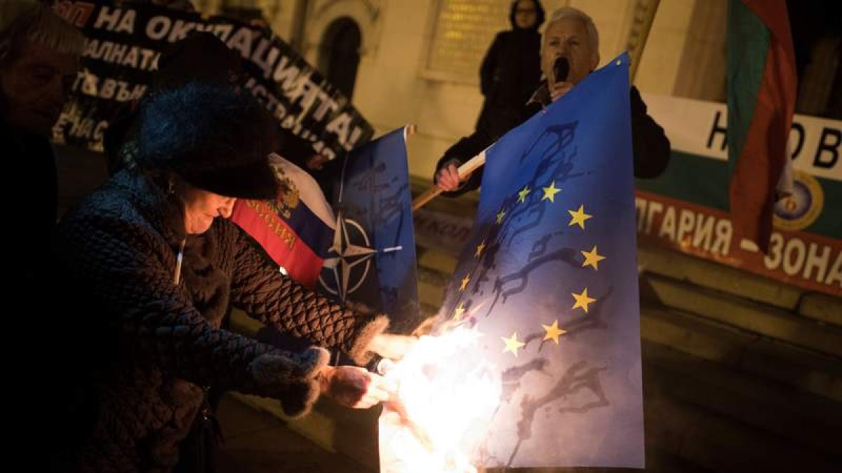 Una manifestante quema una bandera de la Unión Europea durante una protesta en Sofía. VASSIL DONEV