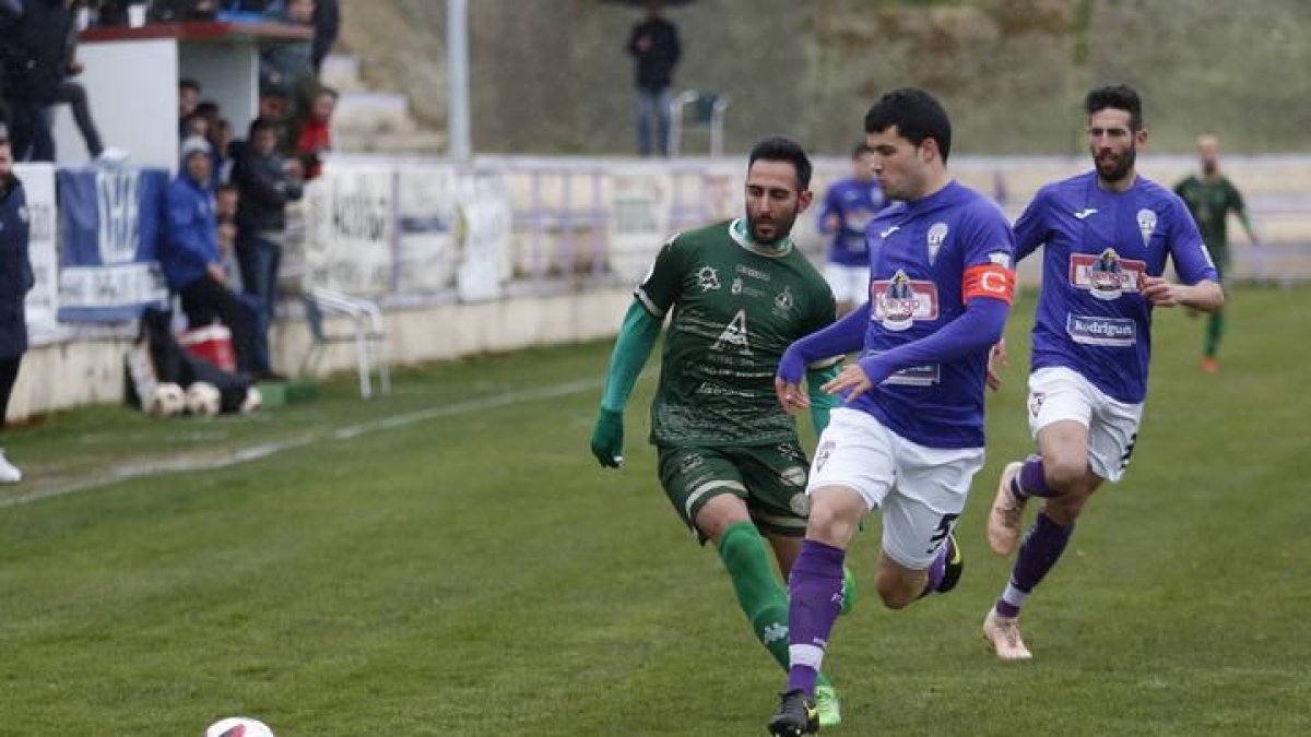 Roberto Puente, el goleador astorgano (izda), se va del capitán bañezano Rober.