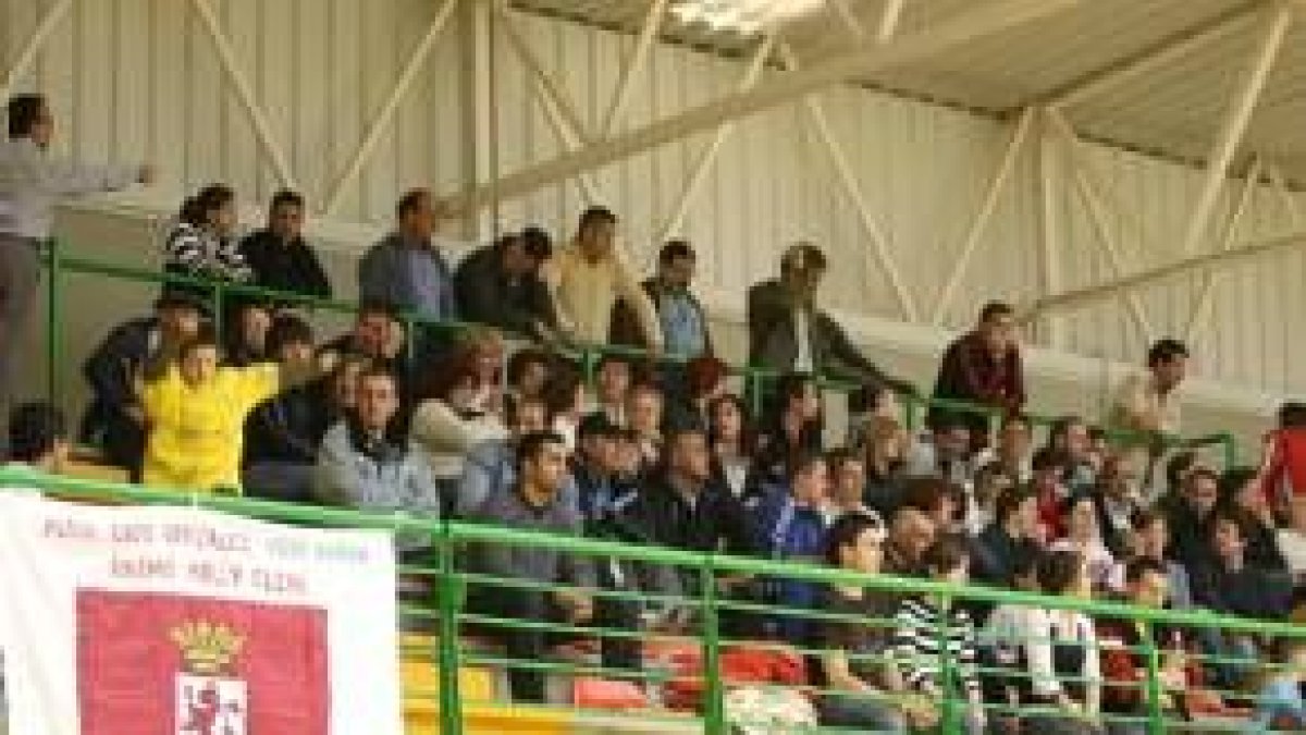 A la izquierda aficionados ayer en el partido, a la derecha el técnico Soto en un tiempo muerto