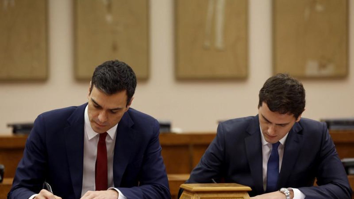 El secretario general del PSOE, Pedro Sánchez (i), y el presidente de Ciudadanos, Albert Rivera, durante la firma de un acuerdo de investidura y legislatura alcanzado entre los dos partidos, hoy en el Congreso de los Diputados.