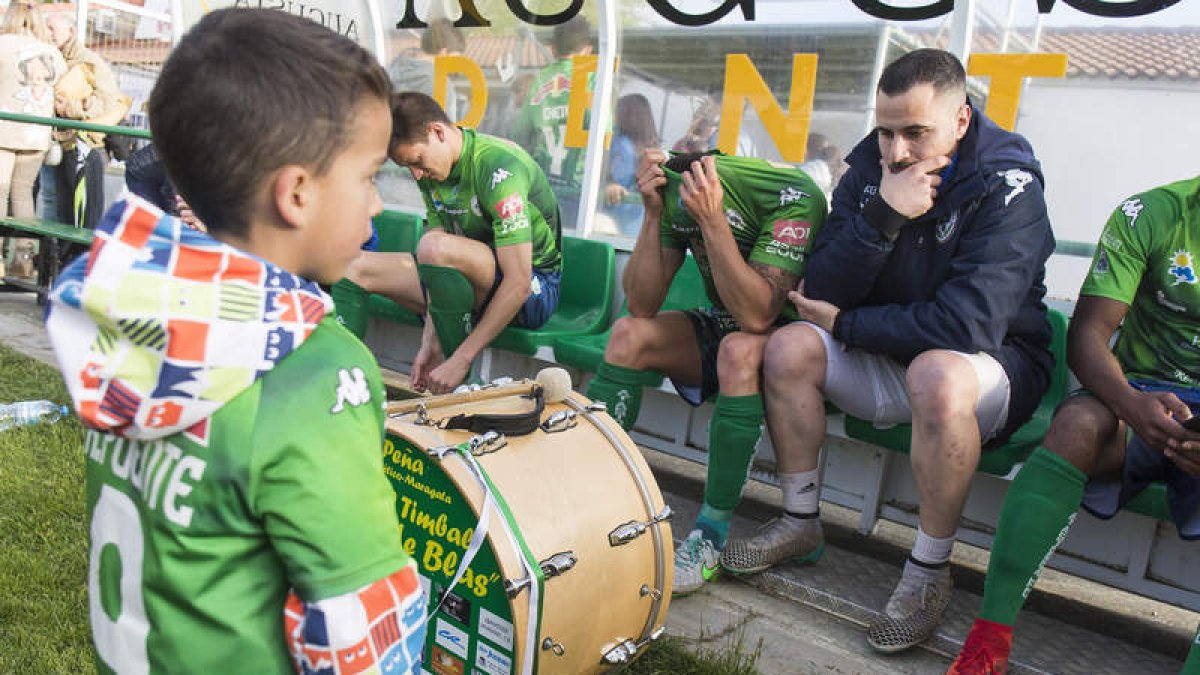 Un niño trata de consolar a los jugadores maragatos pendientes de internet y las radios. FERNANDO OTERO