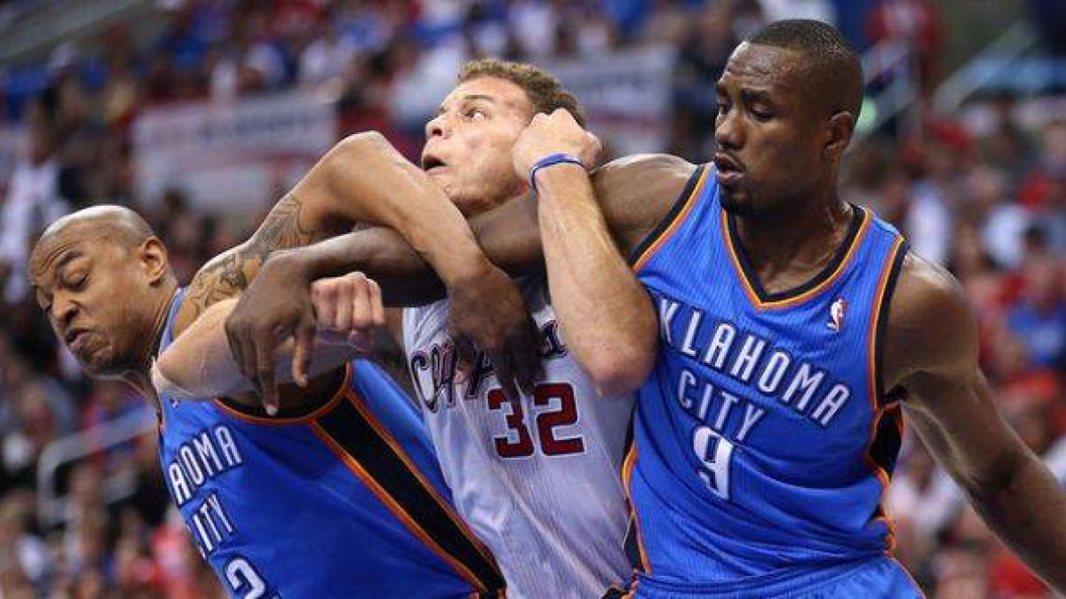 Blake Griffin (centro) trata de deshacerse de Caron Butler (izquierda) y Serge Ibaka.