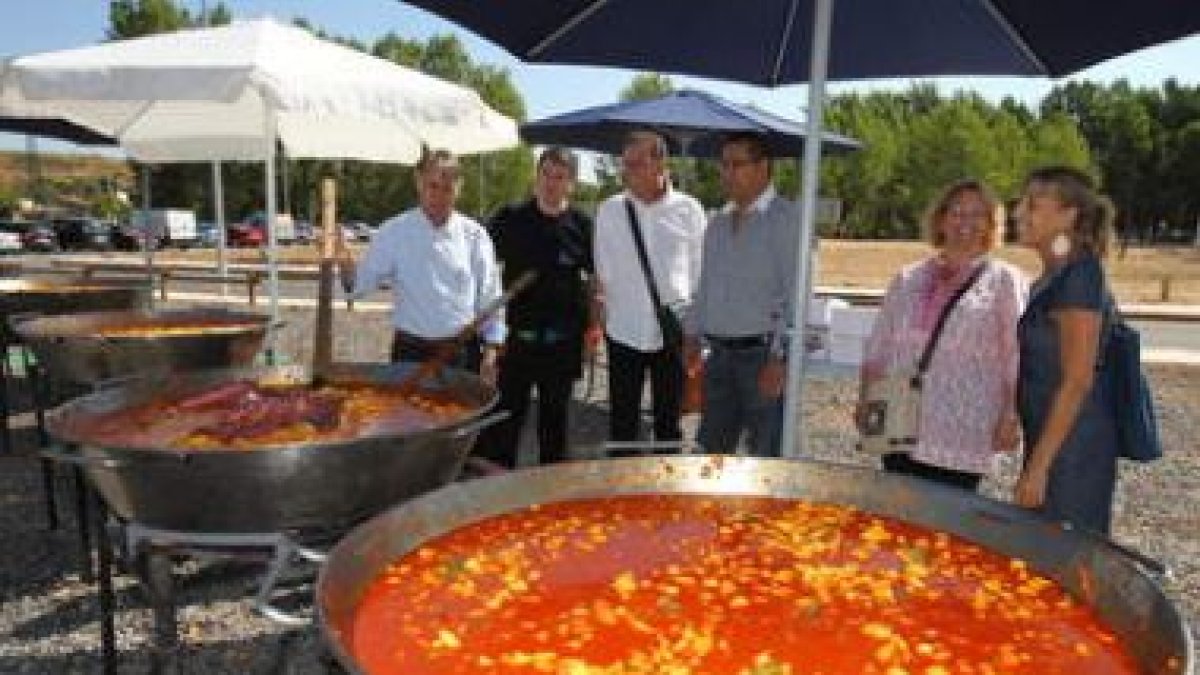 El subdelegado del Gobierno, acompañado del alcalde, junto a las paelleras de pulpo.