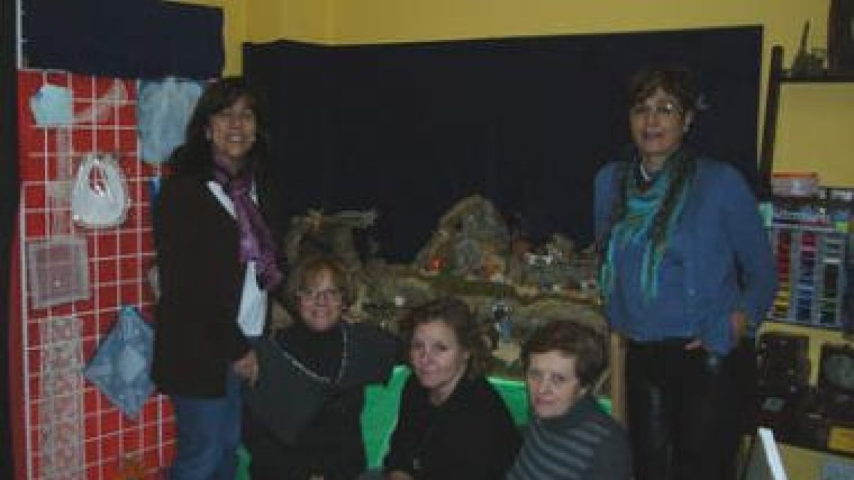 Victoria, y algunas de sus alumnas, posan junto al belén.