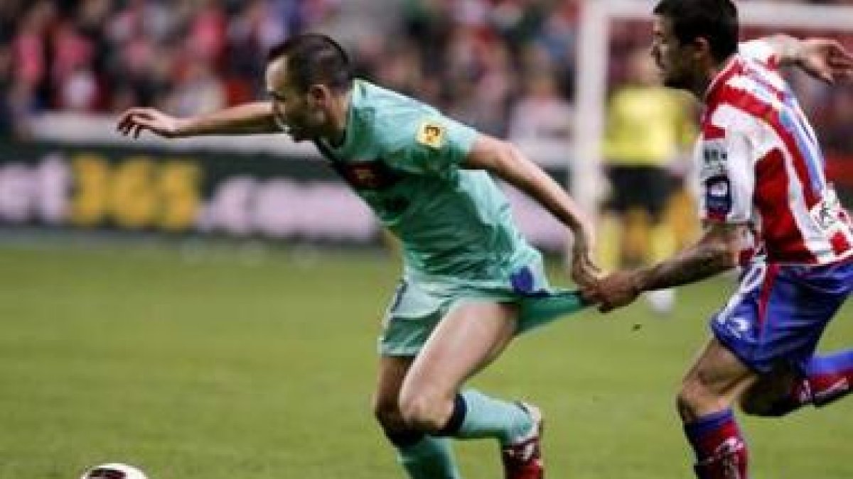 Nacho Novo trata de frenar al barcelonista Andrés Iniesta.