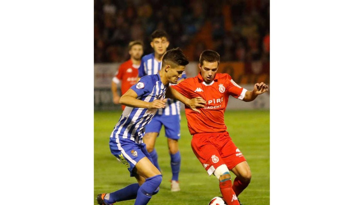 El deportivista Trigueros pelea por la posesión del balón con el culturalista Eneko Capilla en un lance del partido. L. DE LA MATA/MARCIANO PÉREZ