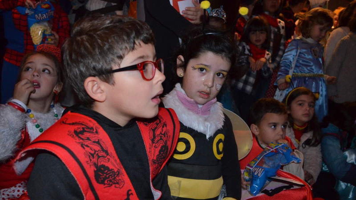 Unos niños observan atentos el espectáculo con el que terminó el desfile infantil de Valencia. medina